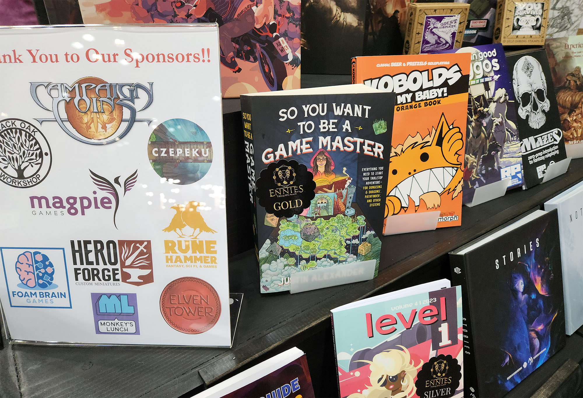 So You Want to Be a Game Master (Justin Alexander) with an ENNIES Gold sticker on the cover.

PIctured in the Gen Con booth near other winners, like Level 1, Kobolds Ate My Baby!, Mazes, Stories, and Koriko.