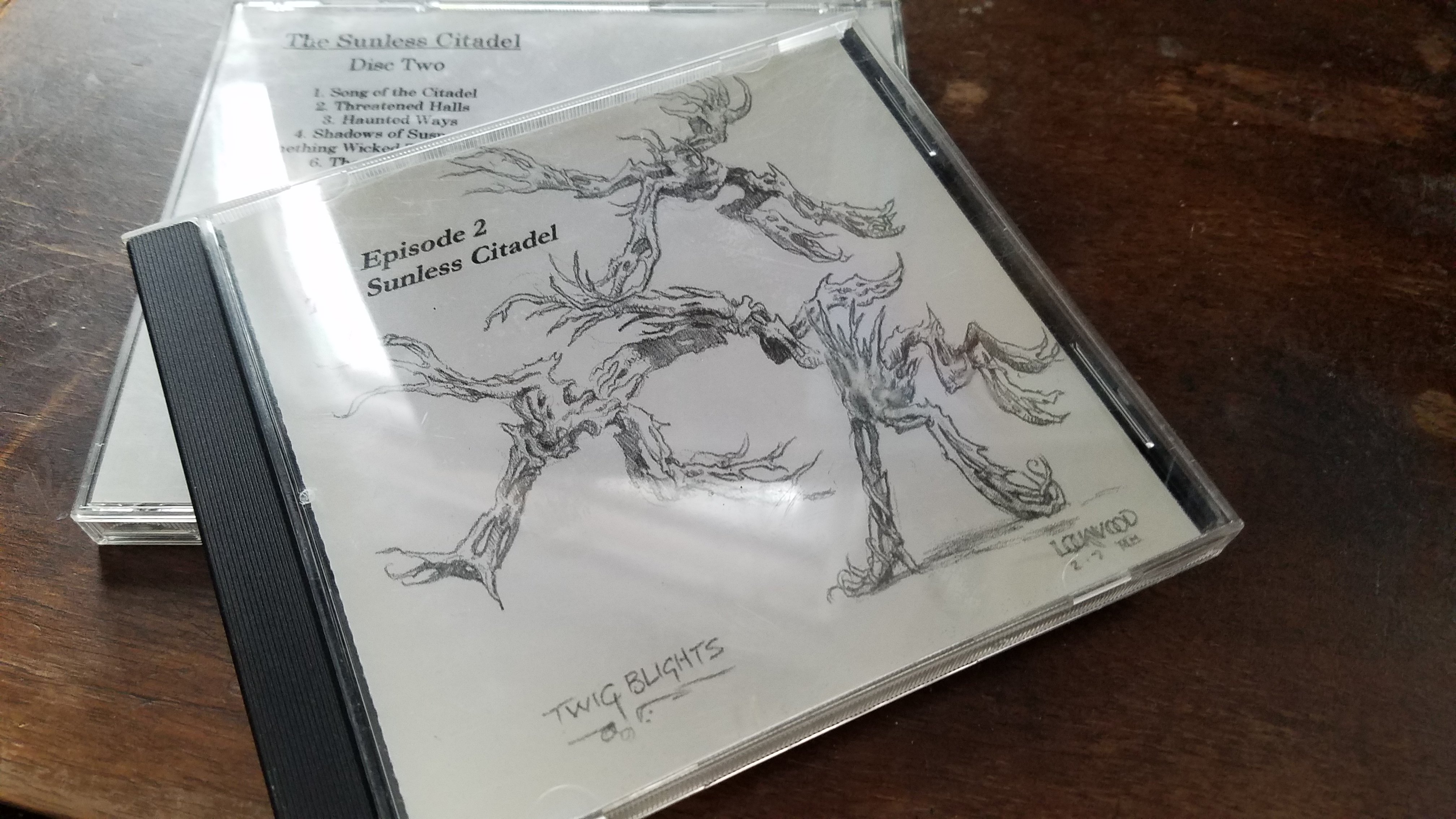 Picture of a CD jewel case. Cover of the CD shows B&W sketch of twig blights. Title: Episode 2 - Sunless Ctiadel