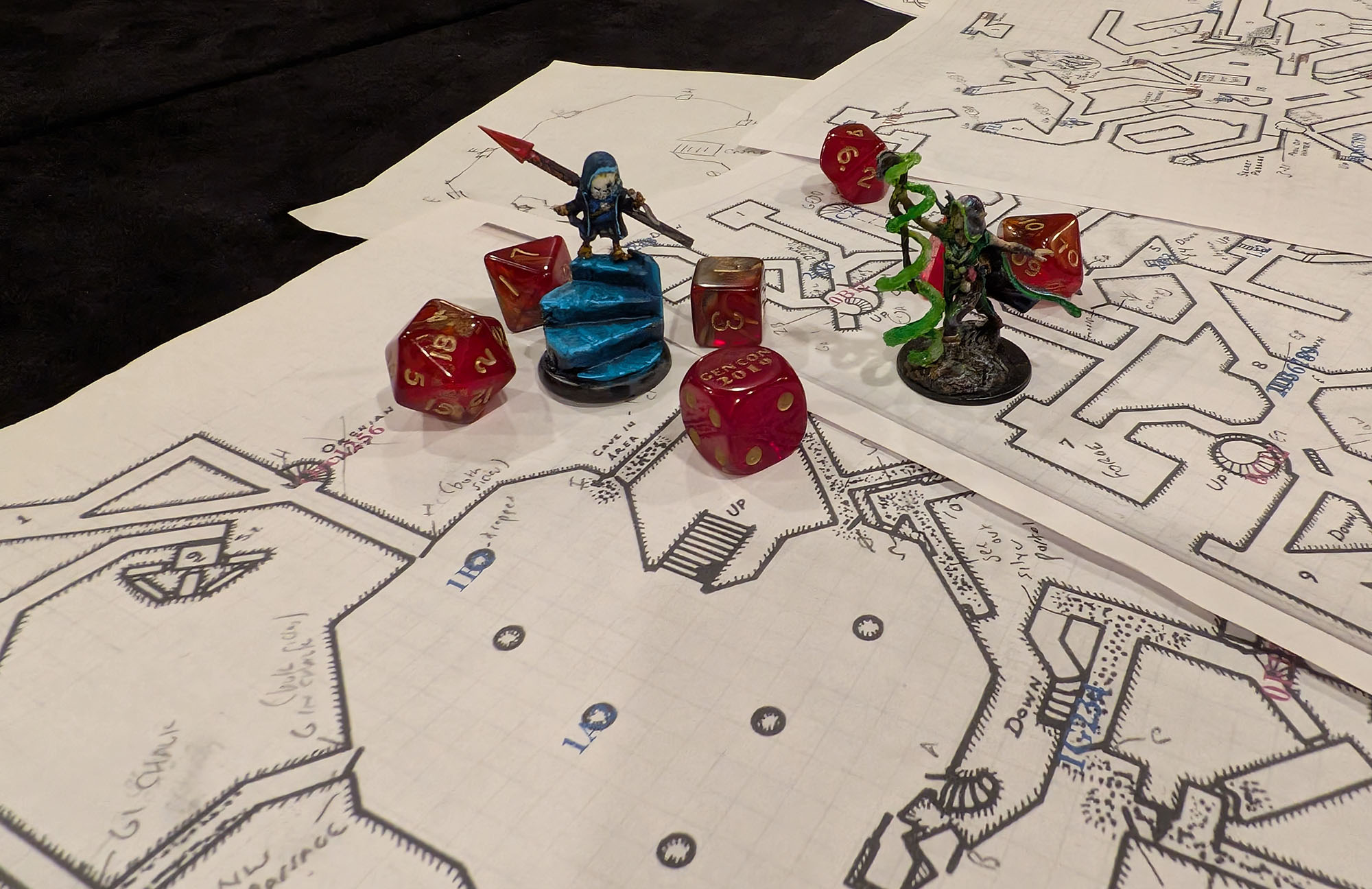 Image of Blackmoor dungeon maps spread on a gaming table, with dice, handwritten notes, and miniatures.